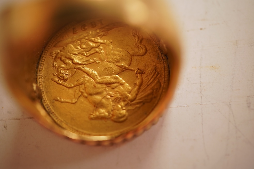 A sovereign ring, 1897 and later, set with a full sovereign dated 1897, to a fluted gold ring mount, size S (sizing band), ring mount stamped 9ct, gross weight 17 grams, Condition: typical surface wear